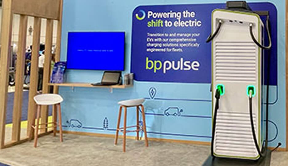 BP Pulse exhibition area showcasing an electric vehicle charger, branded signage, and seating setup.